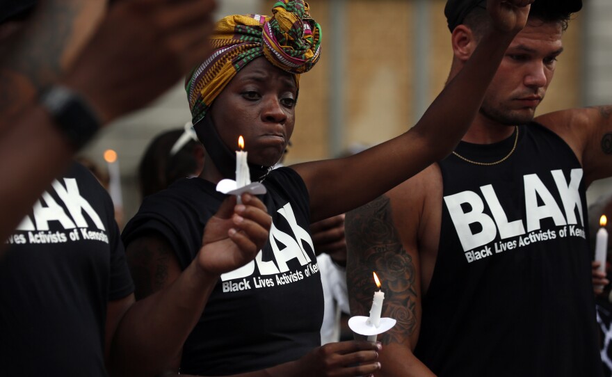 Members of Black Lives Activist of Kenosha Porche Bennett and Nick Larsen react as they participate in a candle light vigil in Kenosha, Wisconsin, Friday, August 28.