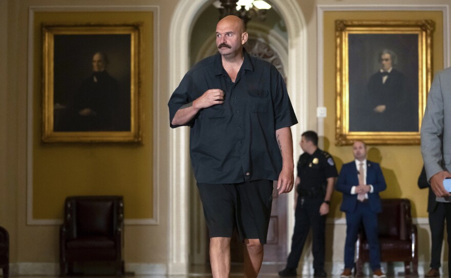 Sen. John Fetterman, D-Pa., walks on Capitol Hill on Thursday. He says he will continue to wear a suit on the Senate floor in compliance with the newly codified dress code.