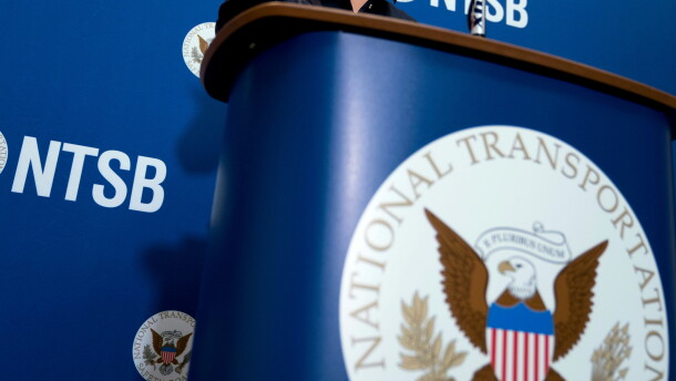 FILE - The National Transportation Safety Board logo and signage are seen at a news conference at NTSB headquarters in Washington, Dec. 18, 2017.