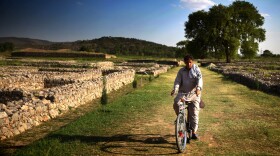 A man rides his bike down the former main street of the ancient city of Sirkap, which was a crowded settlement more than 2,000 years ago. Villagers now use the street as a shortcut home.