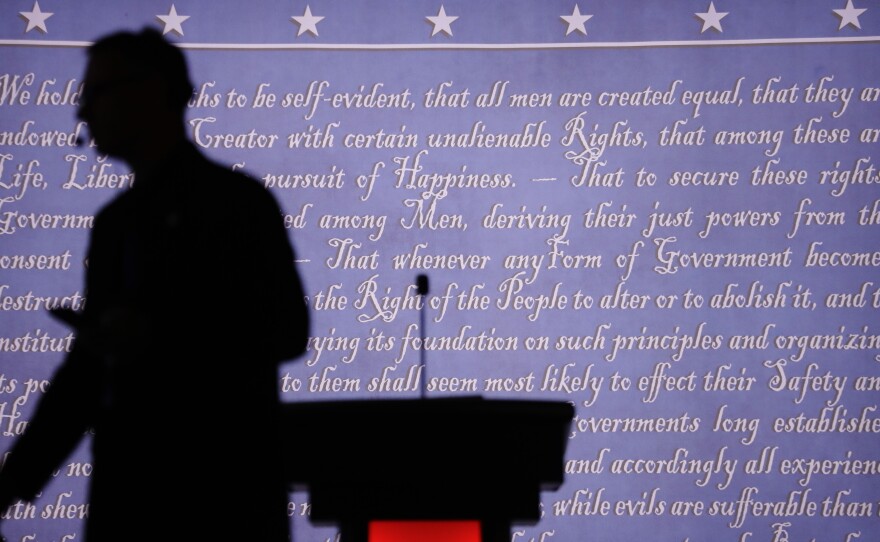 A producer walks past a lectern on the stage of the first presidential debate. The vice presidential debate is Monday night between Democrat Tim Kaine and Republican Mike Pence.