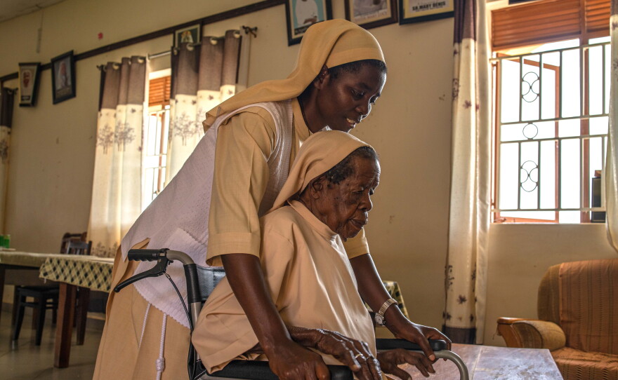 Sister Mary Consolata Nakawoojwa wheels an elderly nun to her room at the Little Sisters of St. Francis premises in Nkokonjeru, Uganda on May 12, 2026.