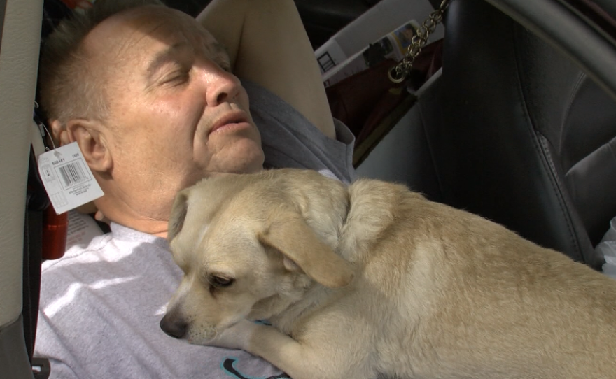 Donald Chester demonstrates how he sleeps in the front seat of his car with his dog, Peanut, Feb. 21, 2017.