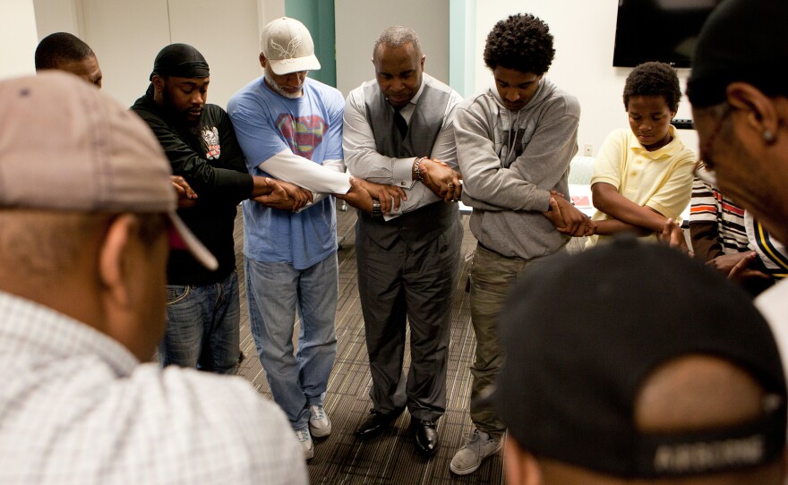 Participants, led by facilitator Eddie Pitchford (center), form the Chain of Unity at the conclusion of the meeting. "God, grant me the serenity to accept the things I cannot change," they chant.