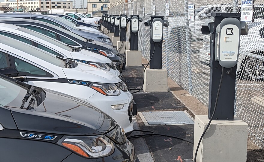 A row of the Navy's electric vehicles, including Chevrolet Bolts, are parked in front of more than a dozen EV chargers at Naval Base San Diego Feb. 17, 2023.