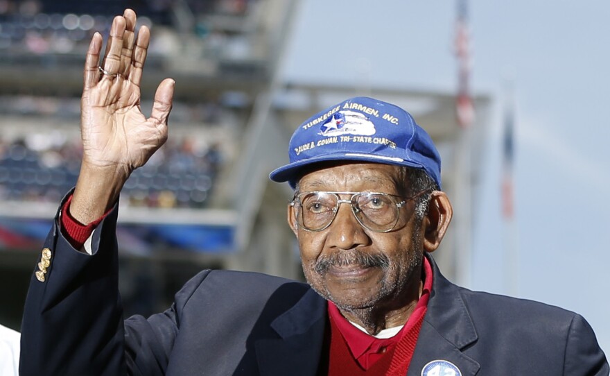 In June 2013, Tuskegee Airman Dabney Montgomery waves to the crowd as he is introduced before the start of a baseball game in New York.