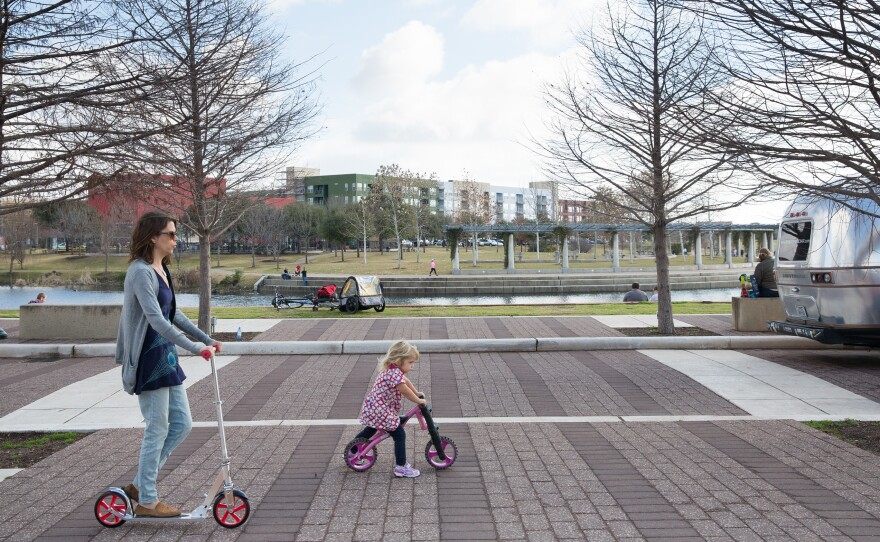 Families hang out at the Mueller farmers market in Austin, Texas, on a Sunday. In a state where cars are king, planners intentionally designed Mueller with pedestrians in mind.