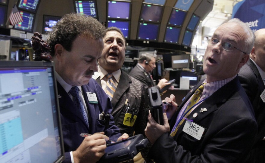 Traders work on the floor of the New York Stock Exchange Wednesday. Stocks soared on news that central banks agreed to work together to support the global financial system.