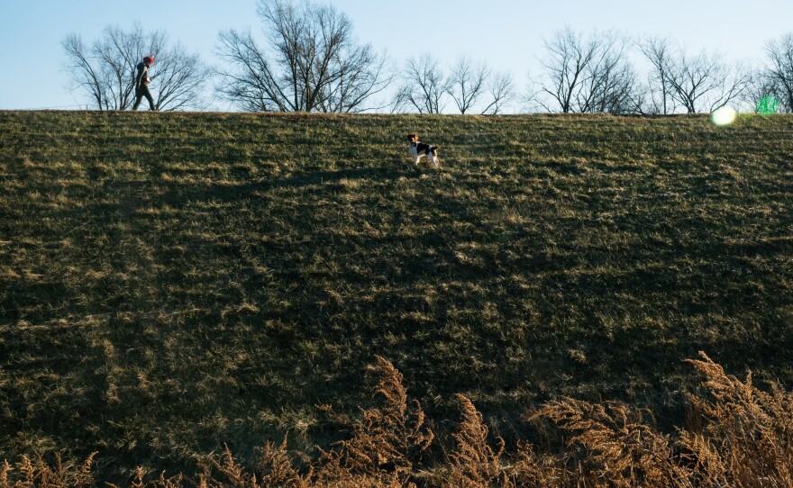 A woman walks her dog on the levee in Bound Brook, N.J. The town, which is just 4 miles from Manville, was awarded a $650 million flood control project.