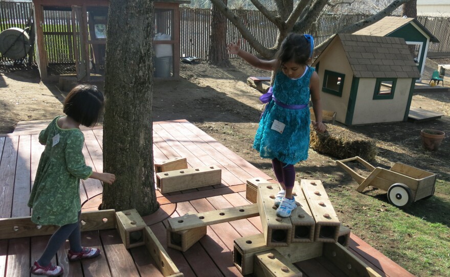 One child's stage is another student's obstacle course. Preschoolers at Bing Nursery School play with outdoor blocks.