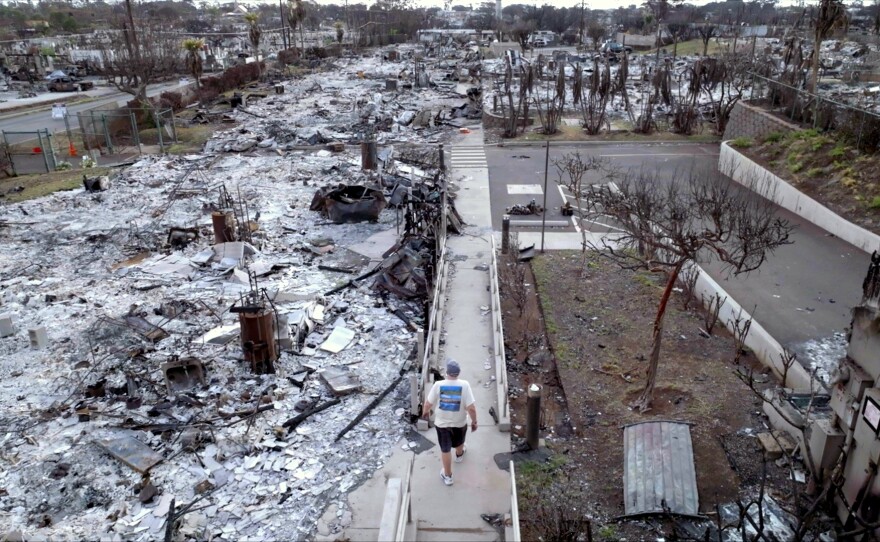 Lahaina resident Sanford Hill walks through the debris of Hale Mahaolu Eono, a senior living community where seven people died in the August 2023 Lahaina fire.
