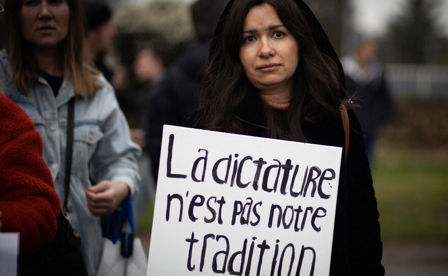 A woman holds a placard reading dictatorship is not our tradition during a gathering of Navalny supporters near the Russian Embassy in Paris on March 17, 2024, during Russia's presidential election.