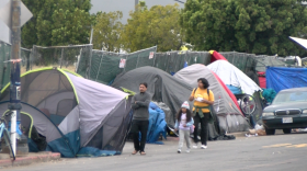 School children walking in the street to avoid homeless encampments on National Street in downtown San Diego on May 30, 2023. 