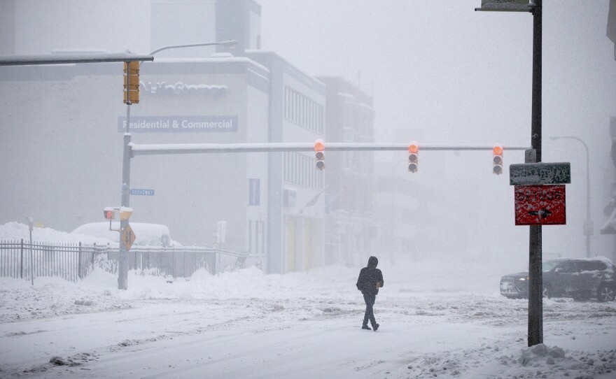 A person crosses Ellicott Street as snow falls Friday, Nov. 18 in Buffalo.