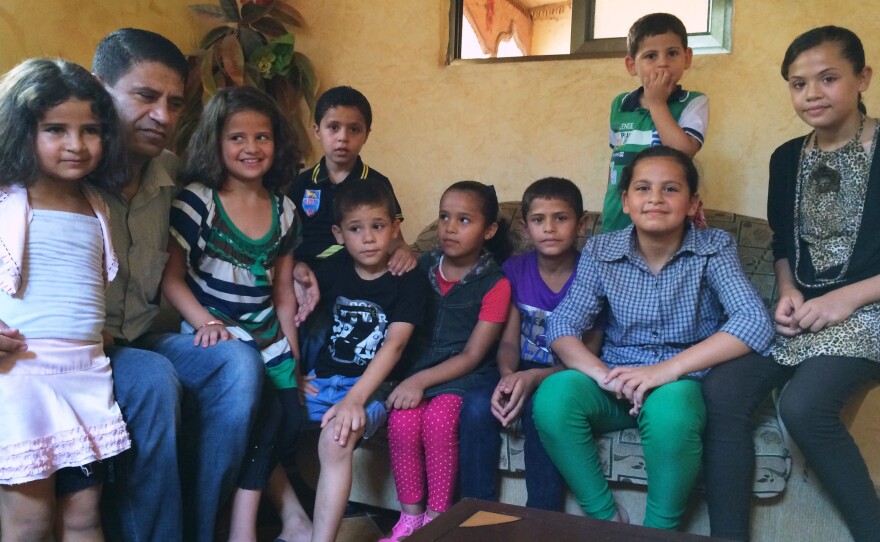 Abdel Karem Shamali, shown with his children and nieces, tries to reassure the kids by acting like the bombs don't bother him.