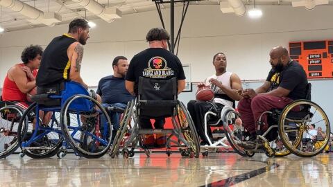 A group of people talk on the court while playing wheelchair basketball in City Heights, Oct. 1, 2025.