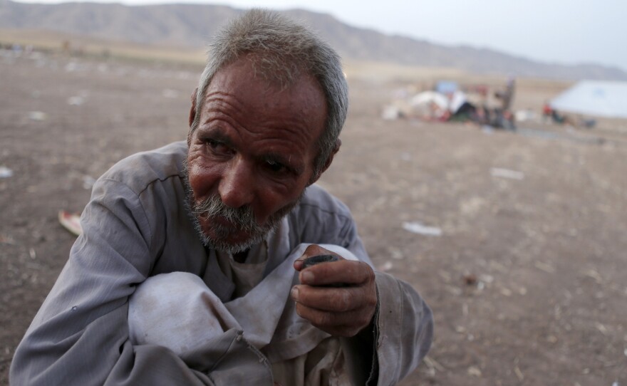 A man from the minority Yazidi sect, who fled the violence in the Iraqi town of Sinjar, sits on the ground at Bajed Kadal refugee camp southwest of Dohuk province on Friday.