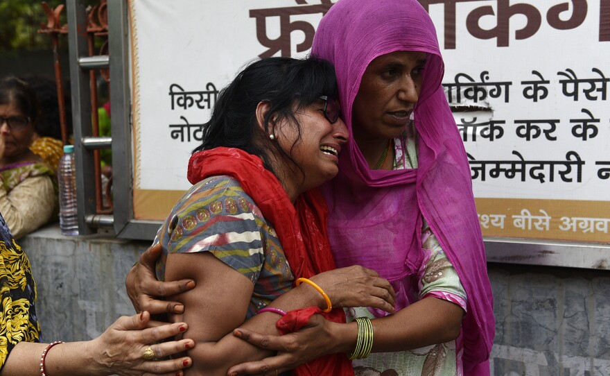 Relatives mourn before the funeral for family members who reportedly died by suicide at their home in Burari, India, this summer.