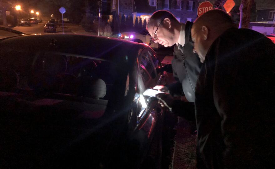 Sgt. Joe Dydak and Lt. Dennis Rosenbaum examine bullet holes in a car. They're part of the Philadelphia Police Department's new citywide team investigating nonfatal shootings.