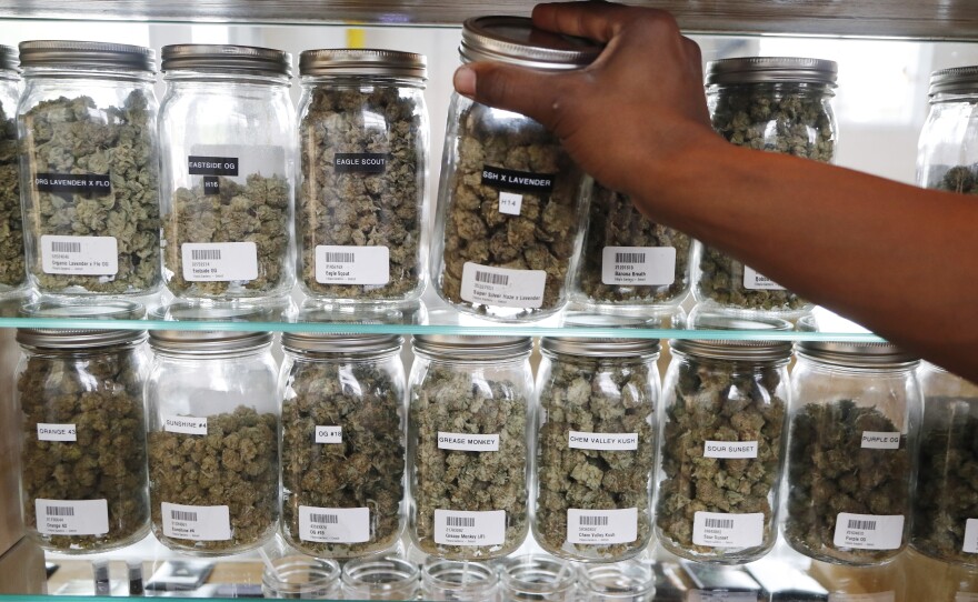 Michigan has become the first state in the Midwest to legalize recreational marijuana, after voters approved a ballot measure Tuesday. Here, a clerk reaches for a container of marijuana buds at Utopia Gardens, a medical marijuana dispensary in Detroit.