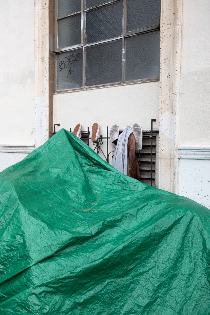 Shoes hang on the side of a building next to a tent in downtown San Diego, March 30, 2023.