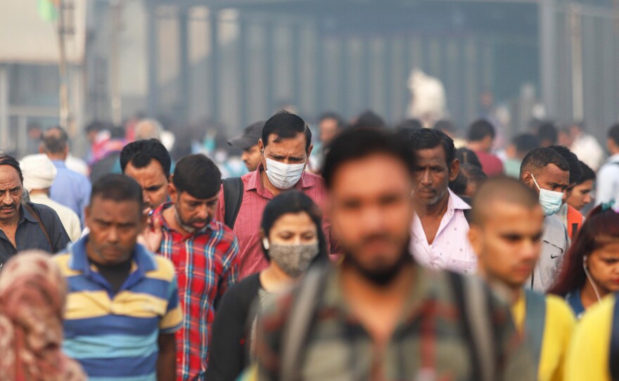 Commuters walk in New Delhi on a smoggy day amid deteriorating air quality levels on Nov. 11, 2022.