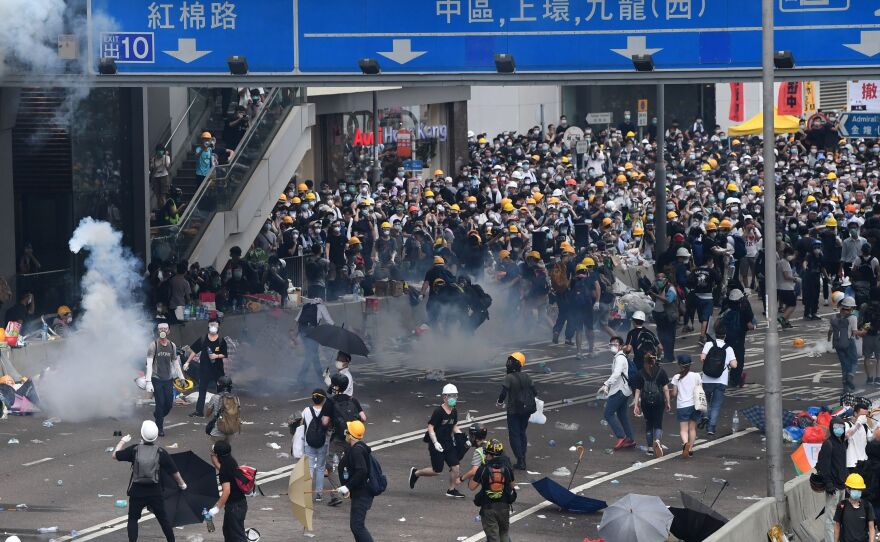 Protesters react after police fired tear gas during a rally against a controversial extradition law proposal outside the government headquarters in Hong Kong on Wednesday.