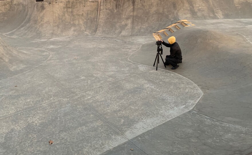 Amir Zaki crouches to snap photos of a skate park at dawn.
