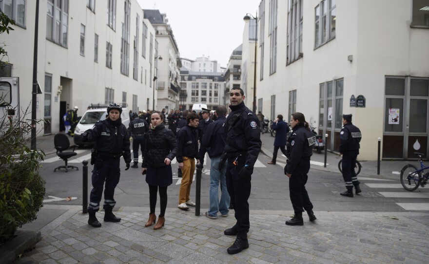 Police forces gather in street outside the offices of the French satirical newspaper Charlie Hebdo in Paris on Wednesday, after armed gunmen stormed the offices.