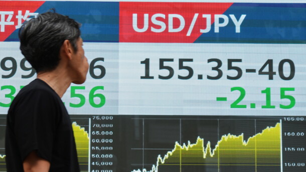 A person walks past an electronic board showing the U.S. dollar and Japanese yen exchange rate at a securities firm in Tokyo on Monday, Aug. 3, 2026.