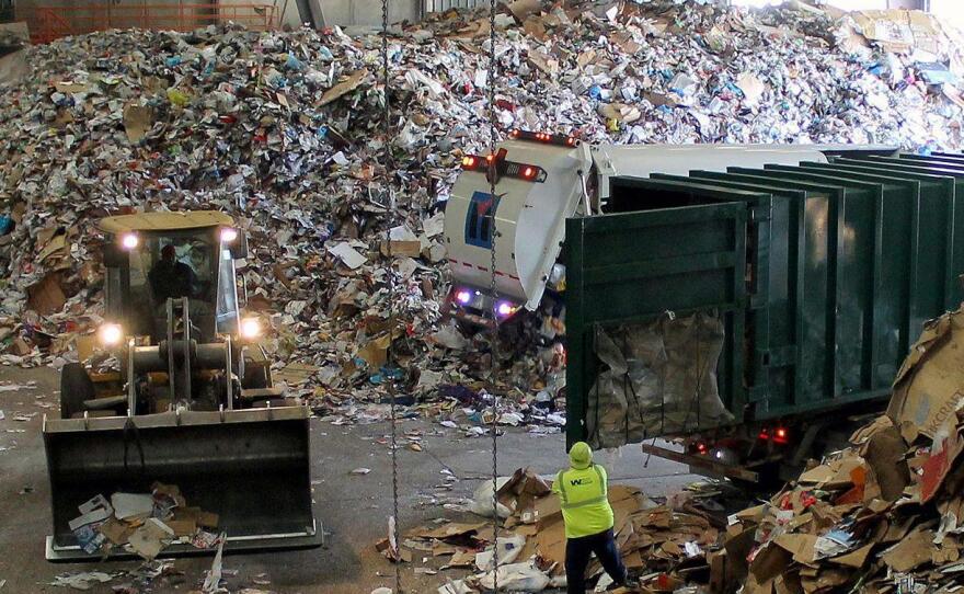 Trucks dump their loads of single-stream recycling on the "tip floor" at Resource Management's MRF in Earth City, Mo.