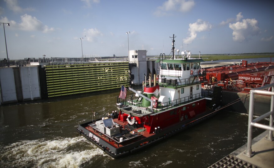 A tug and barge pass through the open flood gates at the 1.8-mile-long Lake Borgne Surge Barrier, which is part of the Southeast Louisiana Flood Protection Authority.