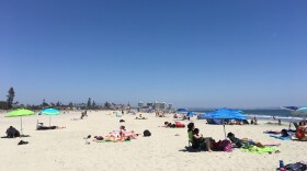 Beachgoers bask in the sun, July 3, 2018. 