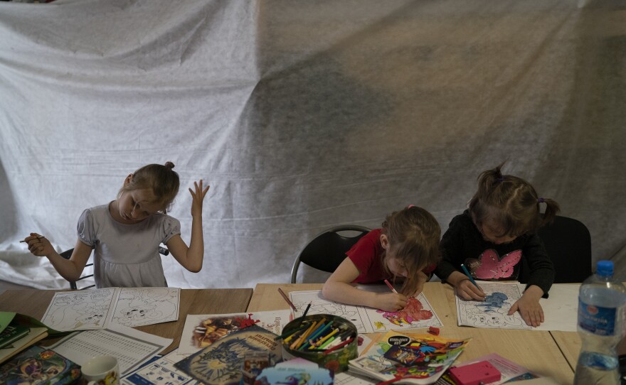 <strong>April 20:</strong> Children draw as they stand in a restaurant that was transformed into a shelter for those fleeing the war from the eastern region of the country in Dnipro, Ukraine.