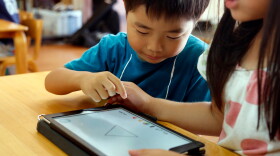 FILE - Children work on a digital program at Coby Preschool in Yoshikawa, suburban Tokyo, July 12, 2018. (AP Photo/Yuri Kageyama, File)