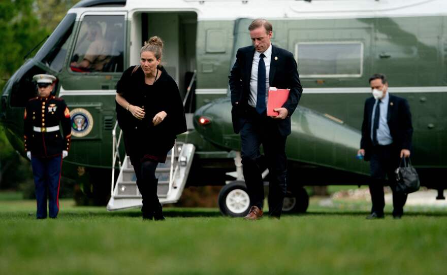 President Biden's national security adviser, Jake Sullivan (second from the right), walks on the South Lawn of the White House in this May 1 photo. Sullivan says U.S. government funding in the rebranded partnership may be relatively modest.