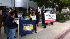 Protesters are pictured rallying outside the La Jolla office of Rep. Scott Peters, May 6, 2015.