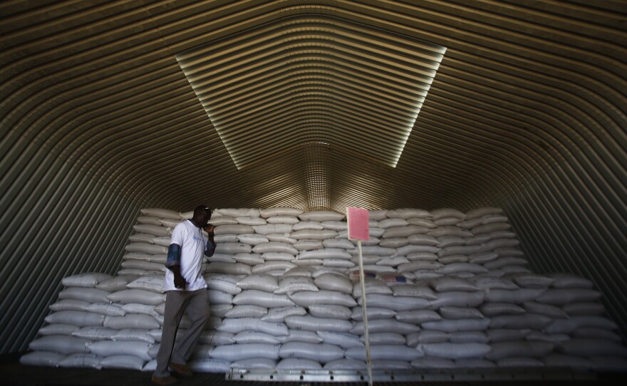 A World Food Programme worker stands next to aid parcels that will be distributed to South Sudanese refugees at the airport in Sudan's North Kordofan state.