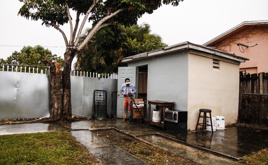 Jorge, seen outside his home, prepares fruit to sell on the streets of Miami. He says he is already feeling the effects of climate change and increasing heat that makes it difficult to be outside.