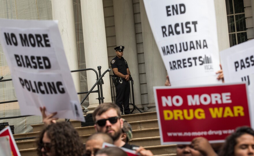 Outside New York City Hall, a policeman watches a protest against racial disparities in marijuana arrests. The majority of those arrested are black or Latino, even though those groups are not more likely to smoke pot.