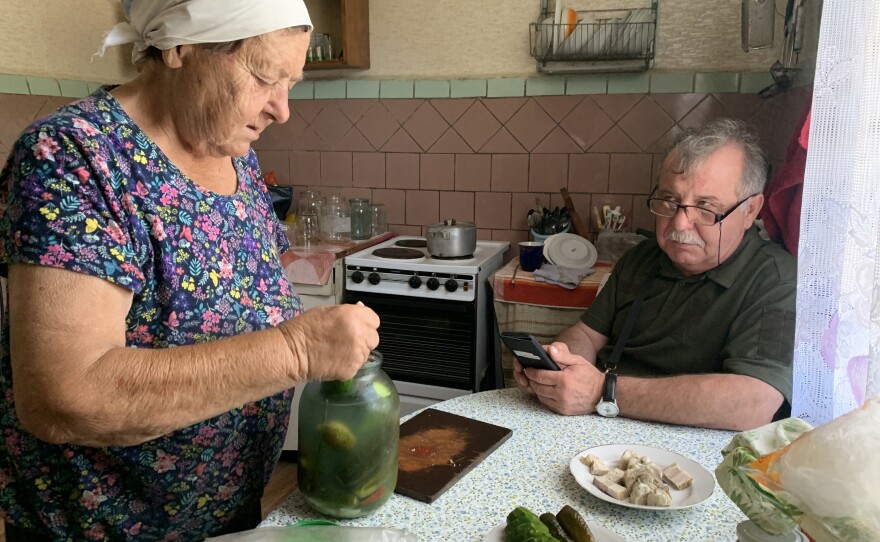 Sophia Arkadiyivna prepares a meal in her home next to Vitaliy Yushkevych, who runs humanitarian aid to people living in the exclusion zone, in Kupovate, Ukraine, on Aug. 29.