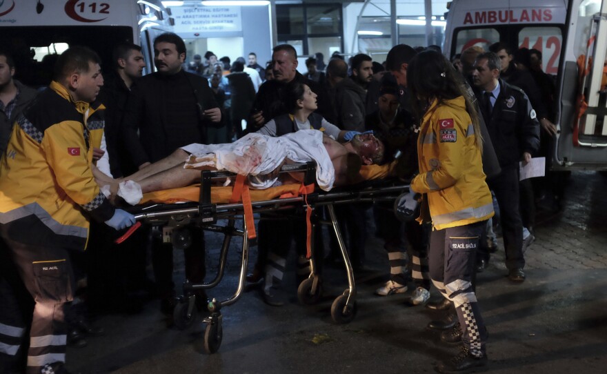 Rescue and medics carry a wounded person after attacks in Istanbul, late Saturday. Two explosions struck outside a major soccer stadium in Istanbul after fans had gone home.