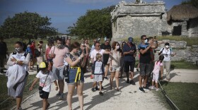 Tourists, required to wear protective face masks amid the new coronavirus pandemic, visit the Mayan ruins of Tulum in Quintana Roo state, Mexico, Tuesday, Jan. 5, 2021. 