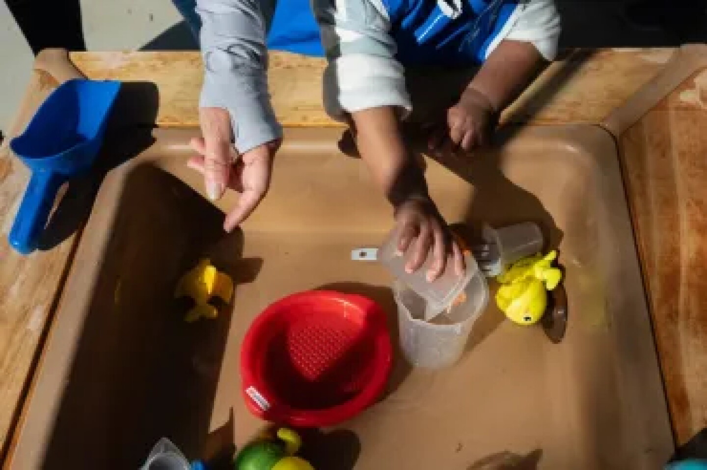 A toddler plays with a water table in an outdoor playground at Kidango Toyon Early Learning Center in San Jose on Sept. 15, 2026.