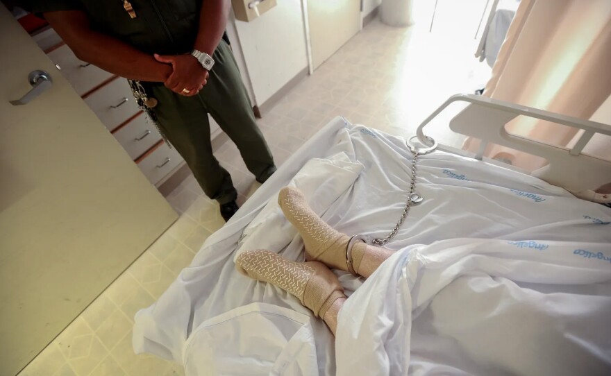 A correctional officer keeps watch over a prisoner in an undisclosed California medical facility near San Francisco on May 18, 2021.