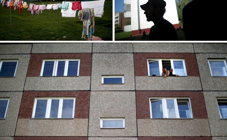 Syrian refugees look out of the windows of the Pentagon apartments, where they are temporally being housed in New Hardenberg, Germany.