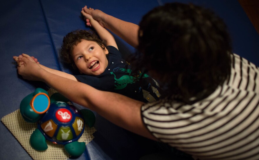 Muldoon helps Gideon stretch as he wakes up at their home in Peoria, Ariz.