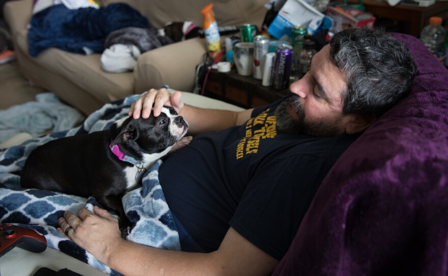 Michael Marquette pets his dog, Spring, while resting at his home in Clarksburg, Md., after a recent hip surgery to repair an injury sustained in 2009 during military duty.
