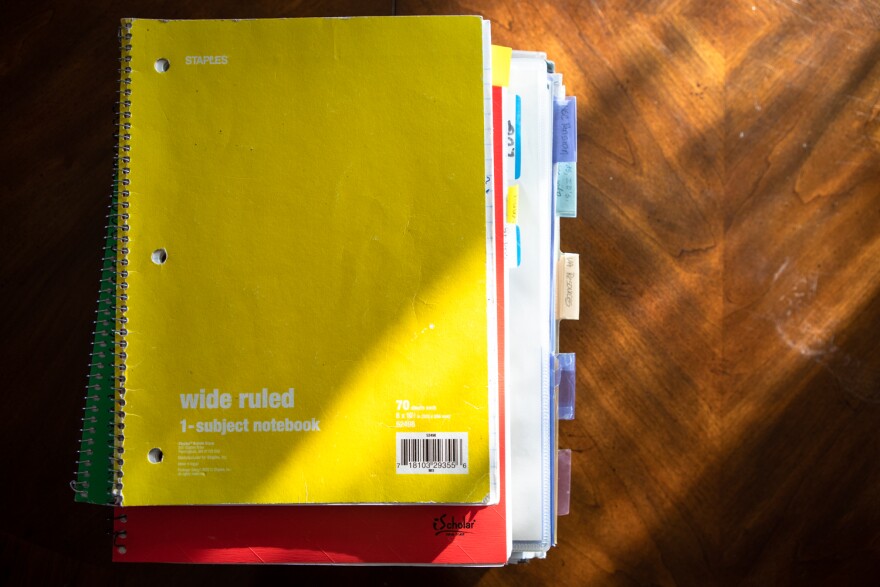 A stack of notebooks kept by Mimi Murray contains notes and information pertaining to her son's care, San Diego, Aug. 22, 2022.
