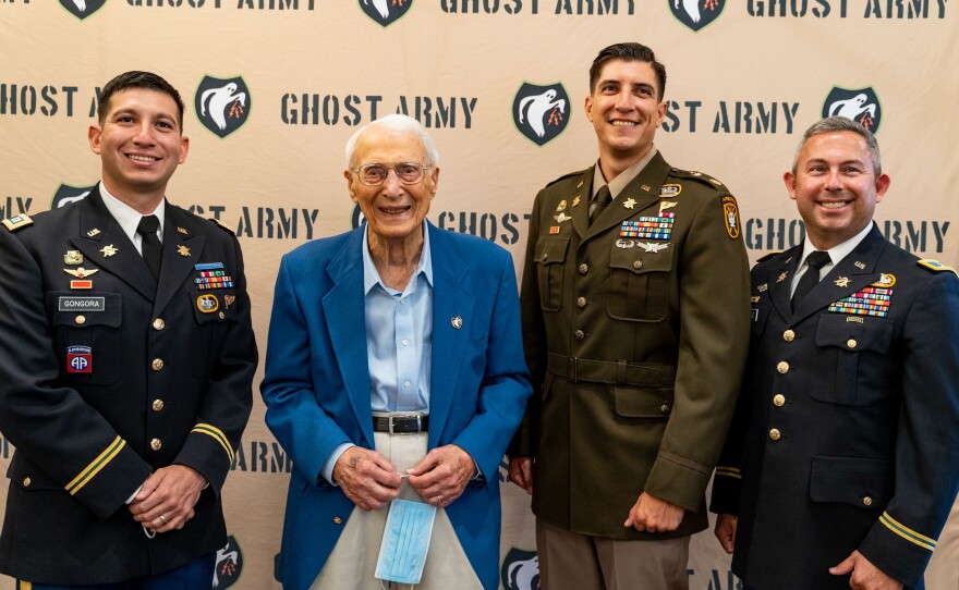 World War II "ghost army" veteran George Dramis of Raleigh poses with members of the modern day Army psychological operations unit in 2022.